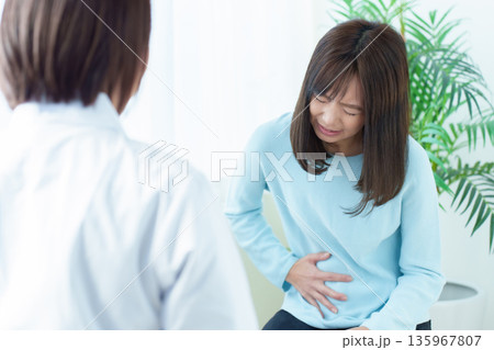 病院で診察を受ける女性 腹痛 体調不良 病院で診察を受ける女性 腹痛 体調不良 135967807