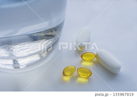 Vitamins and pills with glass of water Vitamins and pills with glass of water 135967819