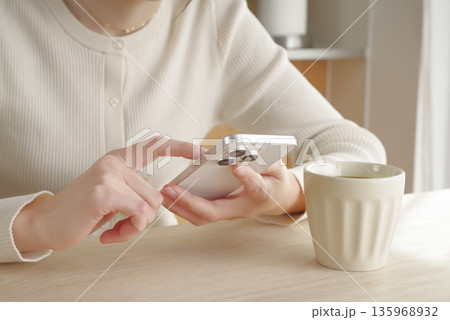 スマホを操作する女性の手元 スマホを操作する女性の手元 135968932