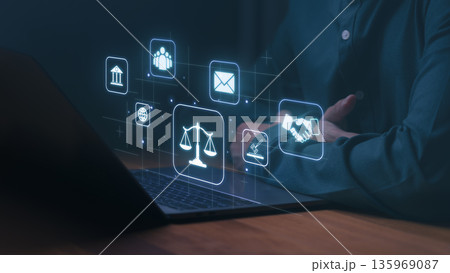 Person using a laptop with digital icons representing law, justice, communication, and business, including scales, handshake, and courthouse symbols, illustrating legal technology and digital ethics. Person using a laptop with digital icons representing law, justice, communication, and business, including scales, handshake, and courthouse symbols, illustrating legal technology and digital ethics. 135969087