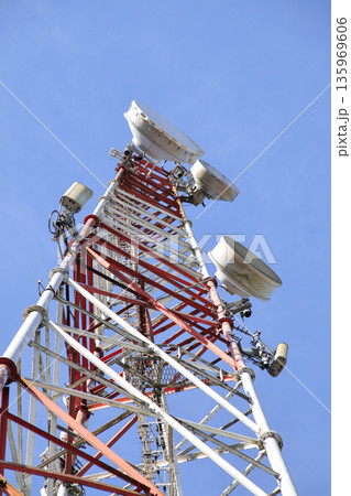 Communication Tower with Antennas Reaching Sky, Red and White Steel Structure for Wireless Broadcast and Telecommunication Infrastructure 135969606