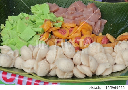 Indonesian Street Food Variety on Banana Leaf, showcasing traditional sweets and snacks under natural light for cultural food experience 135969633