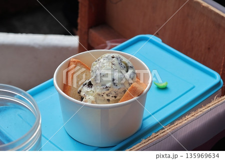 Es Puter in Paper Cup with Bread, Indonesian Street Food Dessert, Displayed on Blue Tray with Natural Light for Culinary Tourism Es Puter in Paper Cup with Bread, Indonesian Street Food Dessert, Displayed on Blue Tray with Natural Light for Culinary Tourism 135969634