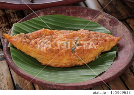 Indonesian Omelette on Banana Leaf Displays Rich Colors and Textures of Authentic Street Food Indonesian Omelette on Banana Leaf Displays Rich Colors and Textures of Authentic Street Food 135969638