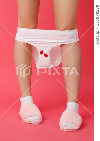 A person stands wearing white underwear and pink slippers A person stands wearing white underwear and pink slippers 135970279