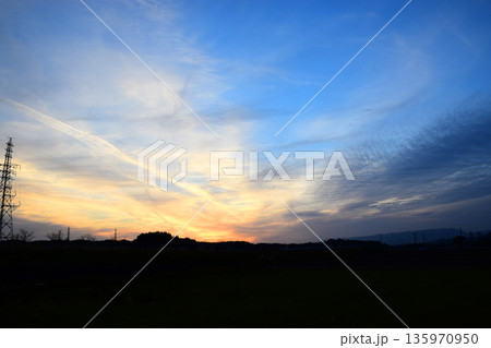 夕焼けに染まった空と鉄塔のイメージ 135970950