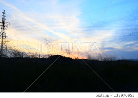 夕焼けに染まった空と鉄塔のイメージ 135970953