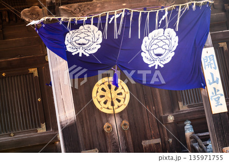 寺院入口を彩る紋入り幕と木扉の伝統的意匠 135971755