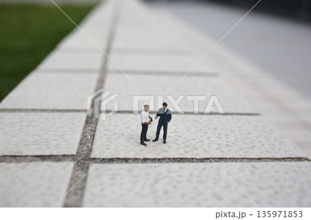 Miniature Business Figures Shaking Hands On Tiled Surface Miniature Business Figures Shaking Hands On Tiled Surface 135971853