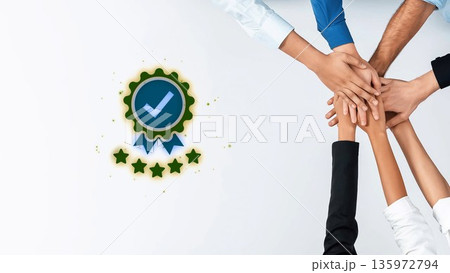 Diverse hands stacking together in cooperation and unity with a green badge symbolizing trust and quality on a light background Gluon 135972794