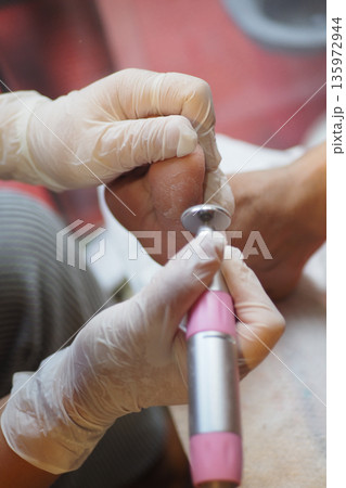 Toenail care is done with a drill in a salon Toenail care is done with a drill in a salon 135972944