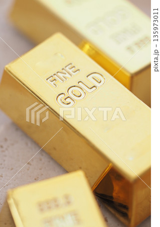Gold bars placed on a table in a bright setting 135973011