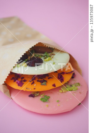 Colorful circular sweets stacked in a paper bag Colorful circular sweets stacked in a paper bag 135973087