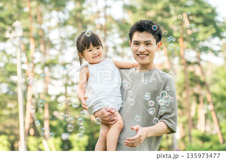 公園で女の子を抱っこして遊ぶパパ,親子,ファミリー（しゃぼん玉） 135973477