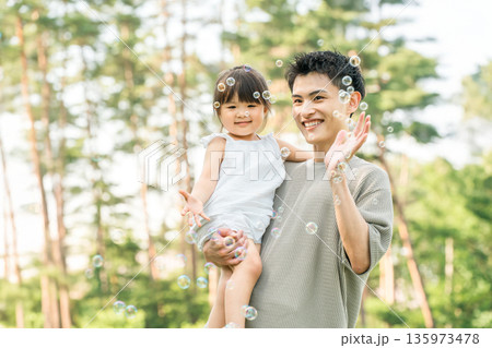 公園で女の子を抱っこして遊ぶパパ,親子,ファミリー（しゃぼん玉） 135973478
