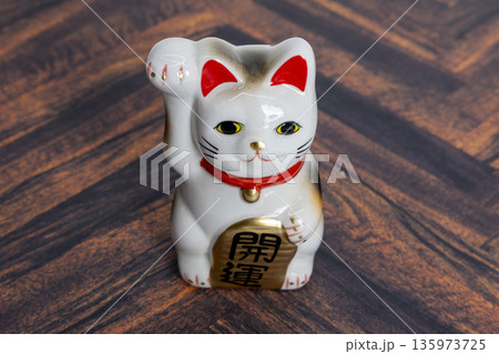 木目背景の招き猫 開運・商売繁盛 木目背景の招き猫 開運・商売繁盛 135973725