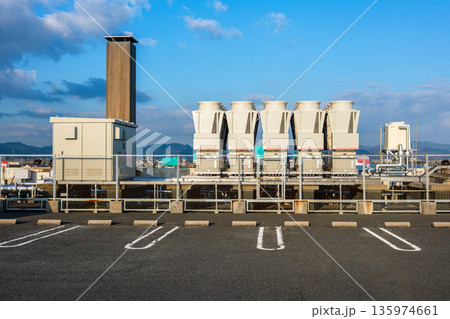 ショッピングモールの屋上に並ぶ空調設備とキュービクル 135974661