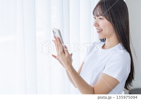 スマートフォンを使う若い女性 135975094