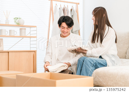 家で引越しの荷造り,処分,断捨離をする夫婦,カップル 家で引越しの荷造り,処分,断捨離をする夫婦,カップル 135975242