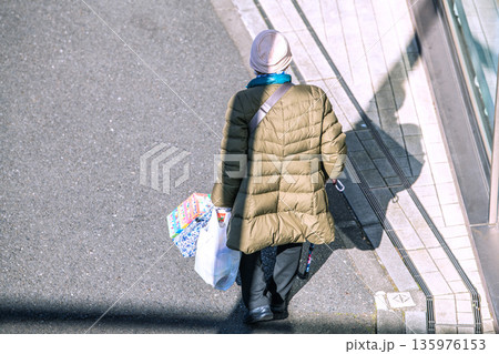日本の横浜都市景観光と“陰”…高齢化社会　杖の高齢女性（マスク姿）。買い物帰り、左手は手袋… 135976153