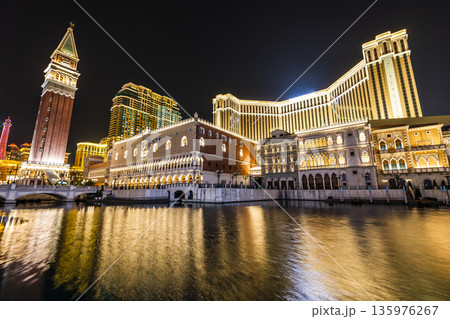 Night view of Venetian buildings in Cotai, Macau, with beautiful reflections of the majestic buildings in the water, owned by the American Las Vegas Sands company. Night view of Venetian buildings in Cotai, Macau, with beautiful reflections of the majestic buildings in the water, owned by the American Las Vegas Sands company. 135976267
