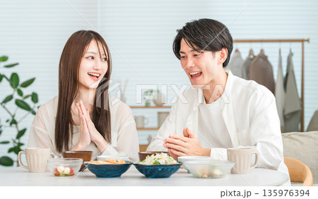 マイホームのダイニングテーブルで食事をする若いアジア人夫婦,カップル マイホームのダイニングテーブルで食事をする若いアジア人夫婦,カップル 135976394