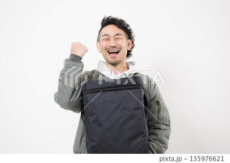 笑顔の配達員がデリバリー用配達バッグを持つフードデリバリー、出前宅配サービスの仕事イメージ 笑顔の配達員がデリバリー用配達バッグを持つフードデリバリー、出前宅配サービスの仕事イメージ 135976621