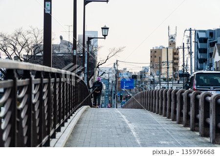 橋の歩道を渡るお婆さん 135976668