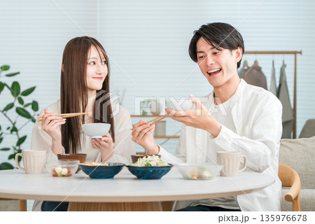 マイホームの食卓で美味しそうに食事をする若いアジア人カップル,夫婦 マイホームの食卓で美味しそうに食事をする若いアジア人カップル,夫婦 135976678