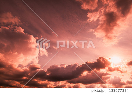 Dramatic Pink Clouds and Sun in Colorful Evening Sky Dramatic Pink Clouds and Sun in Colorful Evening Sky 135977354
