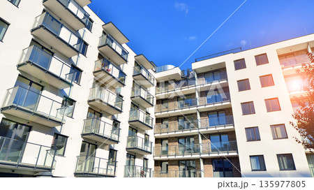 Apartment residential house and home facade architecture and outdoor facilities. Blue sky on the background. Sunlight in sunrise. Apartment residential house and home facade architecture and outdoor facilities. Blue sky on the background. Sunlight in sunrise. 135977805