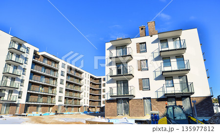Apartment residential house and home facade architecture and outdoor facilities. Blue sky on the background. Sunlight in sunrise. 135977812