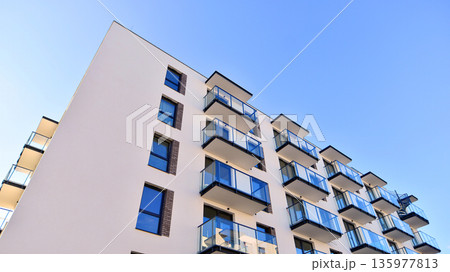 Apartment residential house and home facade architecture and outdoor facilities. Blue sky on the background. Sunlight in sunrise. 135977813
