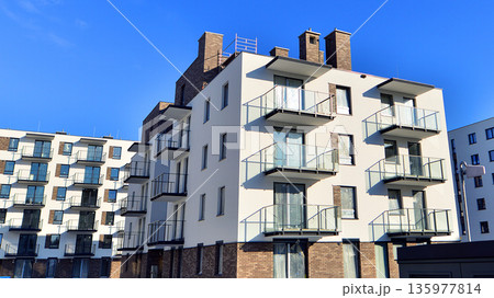 Apartment residential house and home facade architecture and outdoor facilities. Blue sky on the background. Sunlight in sunrise. 135977814