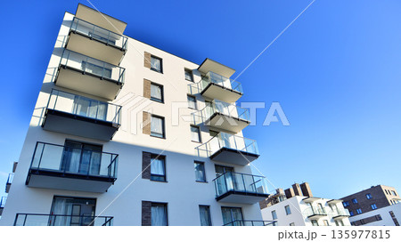 Apartment residential house and home facade architecture and outdoor facilities. Blue sky on the background. Sunlight in sunrise. 135977815