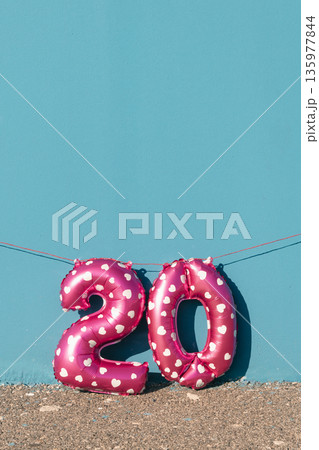 pink number 20 balloons against a vivid blue wall 135977844
