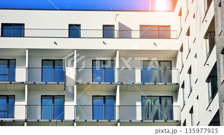 Apartment residential house and home facade architecture and outdoor facilities. Blue sky on the background. Sunlight in sunrise. 135977915