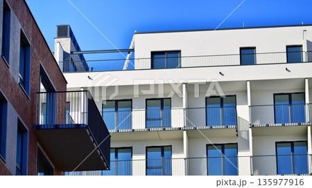 Apartment residential house and home facade architecture and outdoor facilities. Blue sky on the background. Sunlight in sunrise. Apartment residential house and home facade architecture and outdoor facilities. Blue sky on the background. Sunlight in sunrise. 135977916