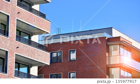Apartment residential house and home facade architecture and outdoor facilities. Blue sky on the background. Sunlight in sunrise. 135977917