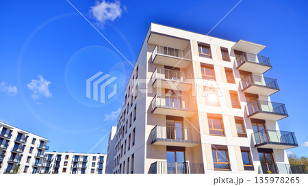 Apartment residential house and home facade architecture and outdoor facilities. Blue sky on the background. Sunlight in sunrise. 135978265