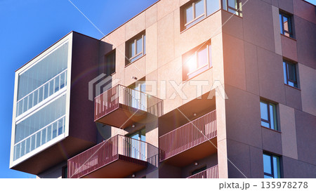 Apartment residential house and home facade architecture and outdoor facilities. Blue sky on the background. Sunlight in sunrise. Apartment residential house and home facade architecture and outdoor facilities. Blue sky on the background. Sunlight in sunrise. 135978278