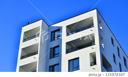 Apartment residential house and home facade architecture and outdoor facilities. Blue sky on the background. Sunlight in sunrise. 135978307