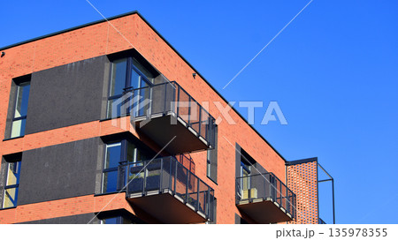 Apartment residential house and home facade architecture and outdoor facilities. Blue sky on the background. Sunlight in sunrise. 135978355