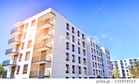 Apartment residential house and home facade architecture and outdoor facilities. Blue sky on the background. Sunlight in sunrise. 135978537