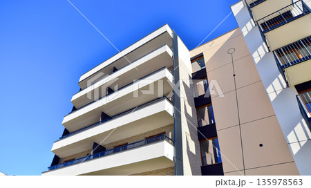 Apartment residential house and home facade architecture and outdoor facilities. Blue sky on the background. Sunlight in sunrise. 135978563