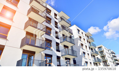 Apartment residential house and home facade architecture and outdoor facilities. Blue sky on the background. Sunlight in sunrise. Apartment residential house and home facade architecture and outdoor facilities. Blue sky on the background. Sunlight in sunrise. 135978610