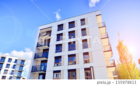 Apartment residential house and home facade architecture and outdoor facilities. Blue sky on the background. Sunlight in sunrise. Apartment residential house and home facade architecture and outdoor facilities. Blue sky on the background. Sunlight in sunrise. 135978611