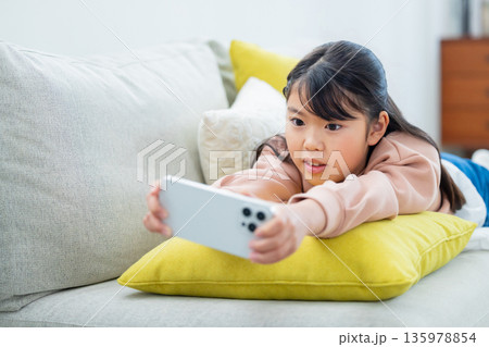 スマホで遊ぶ小学生の女の子 135978854