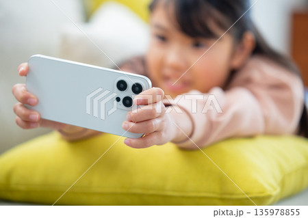 スマホで遊ぶ小学生の女の子 135978855