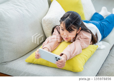 スマホで遊ぶ小学生の女の子 135978856